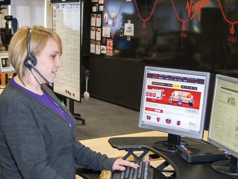 A Virgin Media employee takes calls in a contact centre