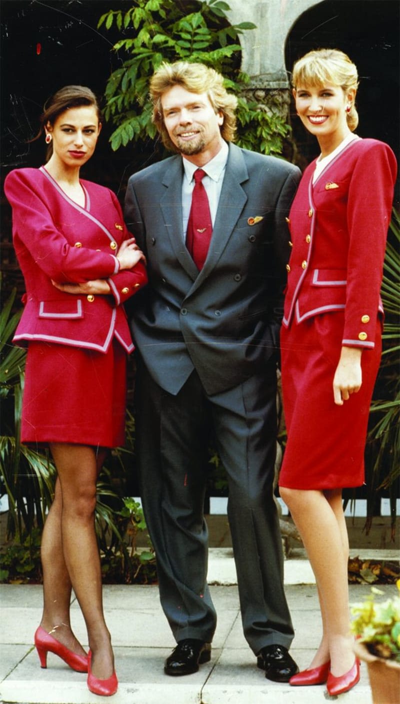 Richard Branson with Virgin Atlantic cabin crew wearing the red Virgin Atlantic uniform designed by David Emmanuel