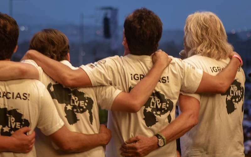 Richard Branson locks arms with others on stage at Venezuela Aid Live