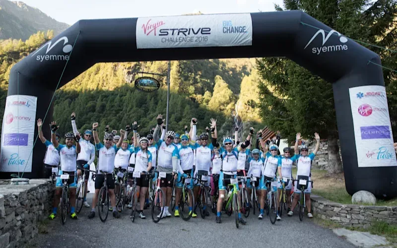 Richard Branson with a group of cyclists at the starting line of the Strive challenge