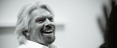 Black and white close up photo of Richard Branson laughing 