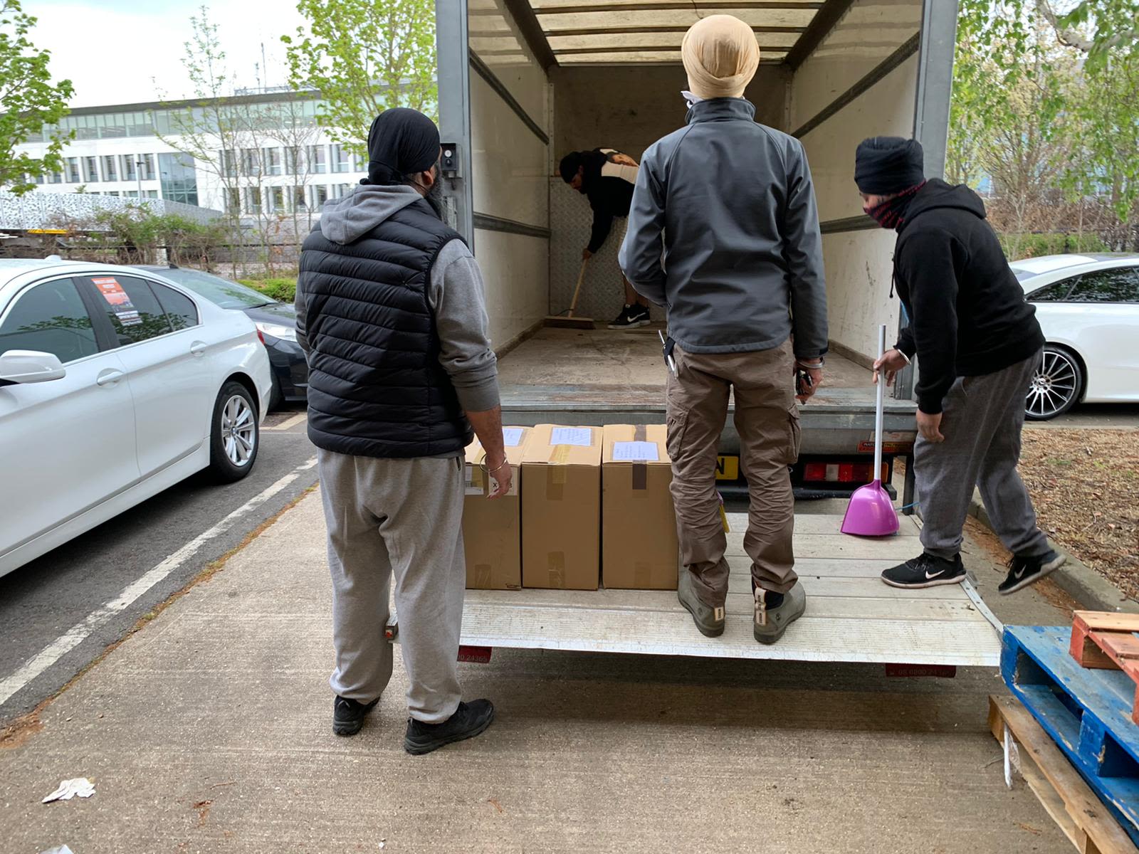 Khalsa Aid volunteers load boxes onto a lorry