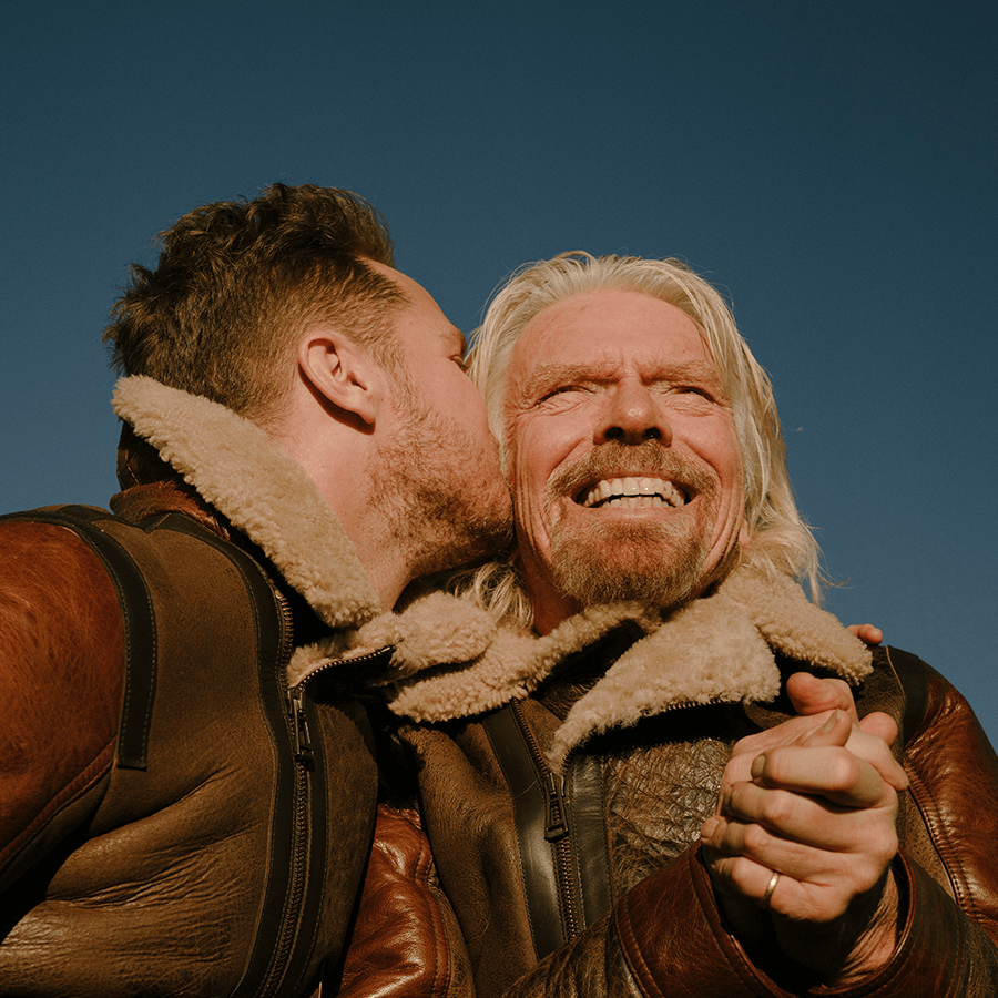 Richard Branson and his son Sam Branson embracing and looking happy 