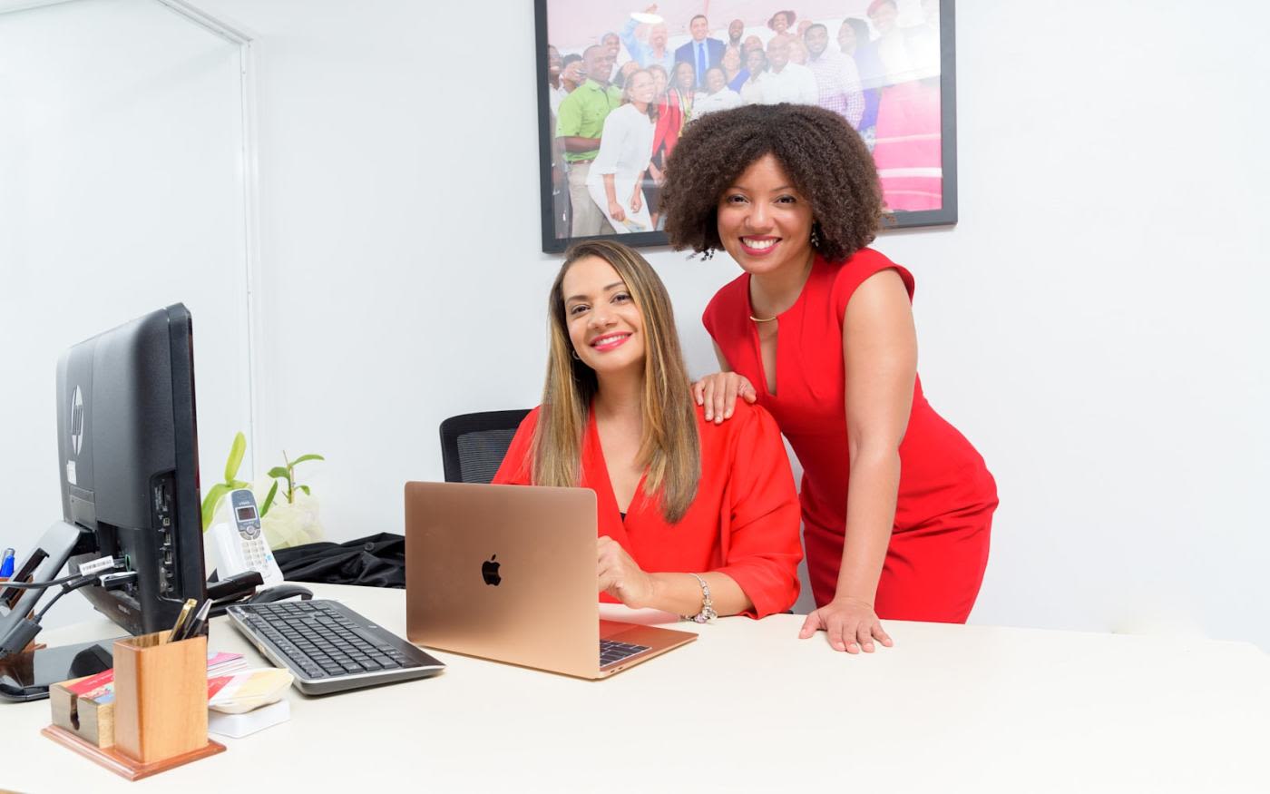 Lauri-Ann Ainsworth, CEO of the Branson Centre Caribbean, sits at a desk with Lisandra Rickards, former CEO of the Branson Centre Caribbean