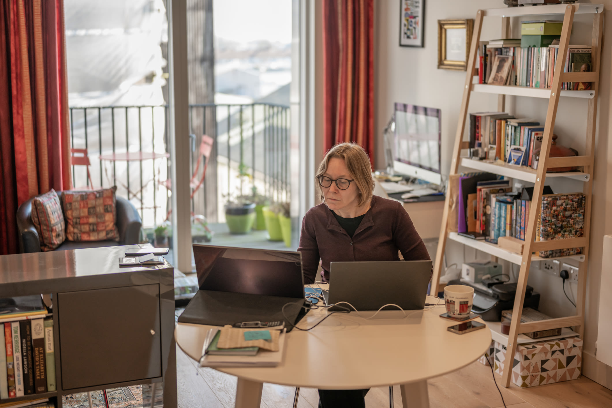 A woman working at her dining room table