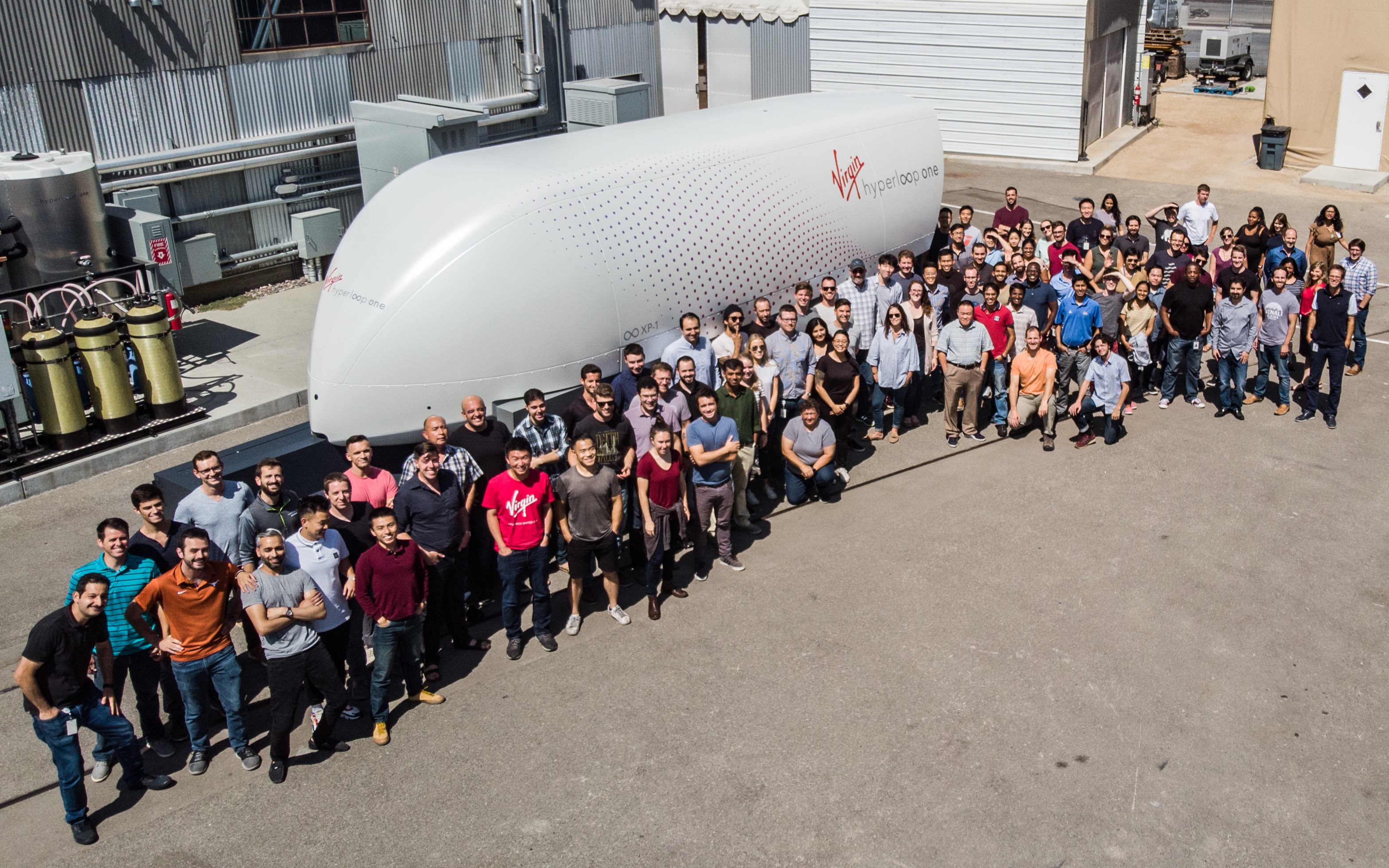 The Virgin Hyperloop team stand in front of the XP-1 pod