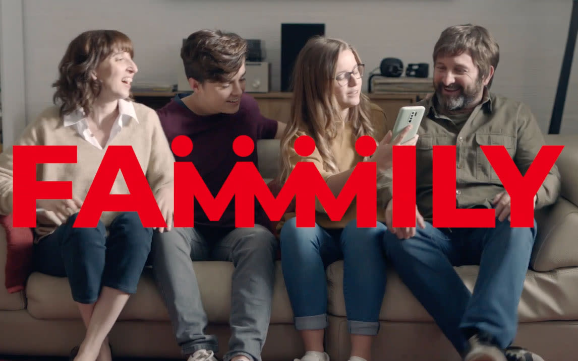 A family sitting on a sofa together. Text reads: Fammmily