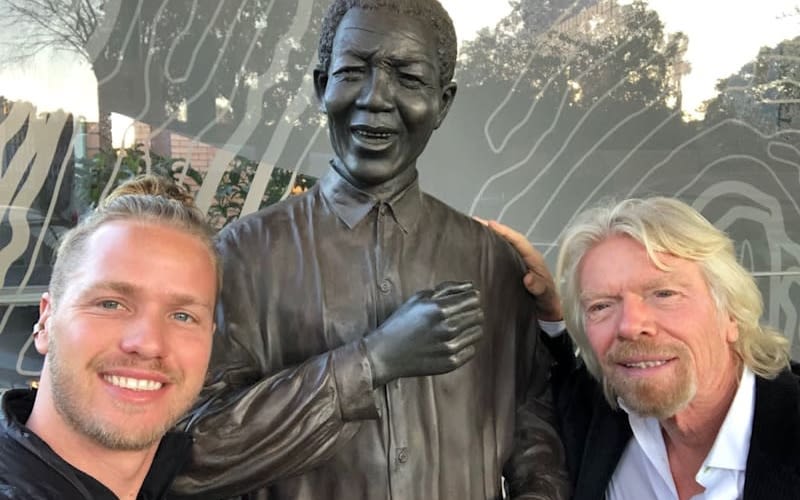 Richard and Sam Branson posing with a statue of Nelson Mandela 