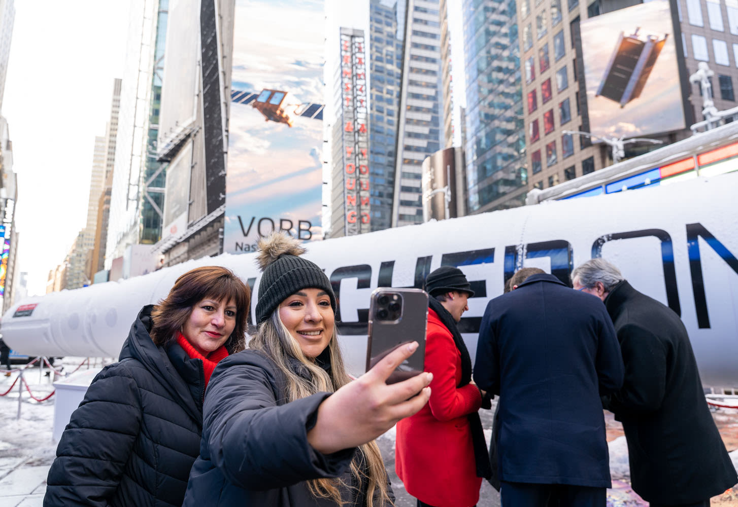 Two members of the public take a selfie in front of LauncherOne rocket in Times Square