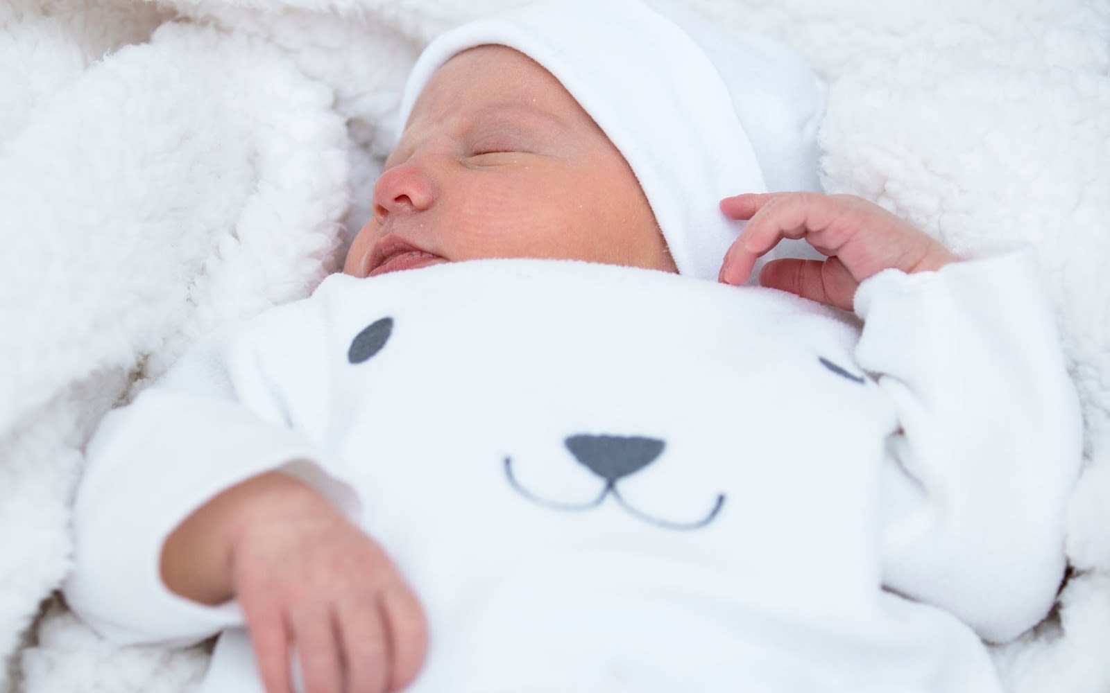 Baby Lola Andrewes dressed in white, sleeping