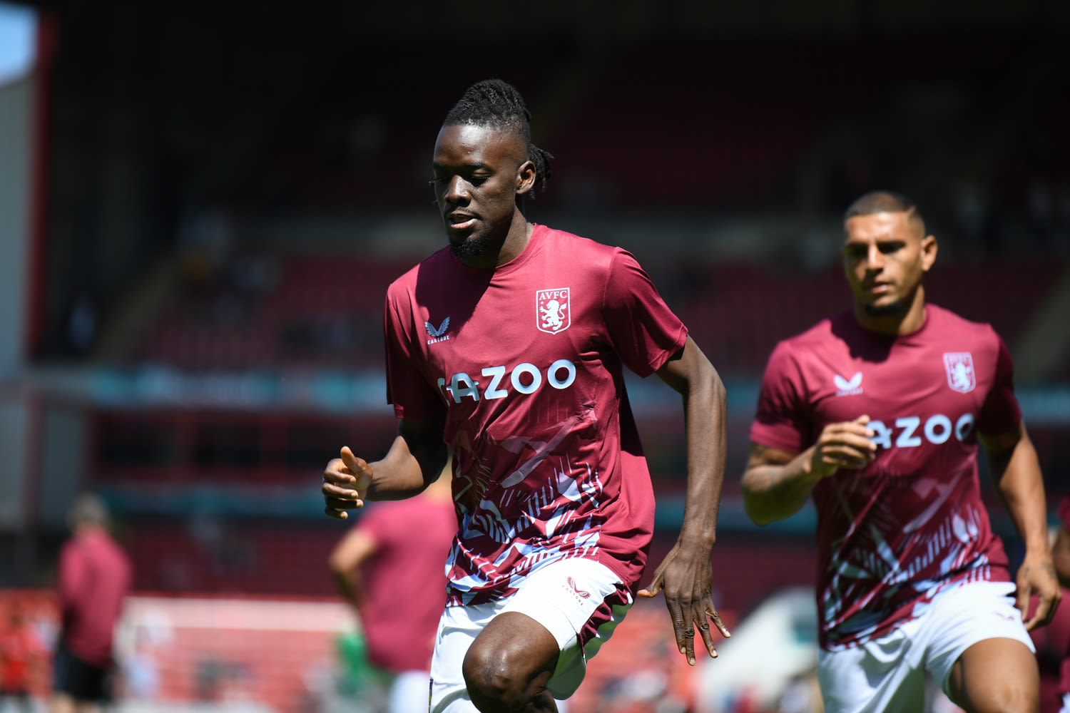 Two football players wearing Aston Villa kits featuring the Castore logo