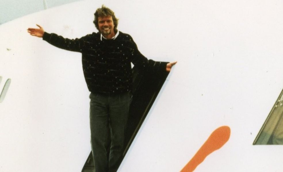 Richard standing  at the entrance of a plane smiling 