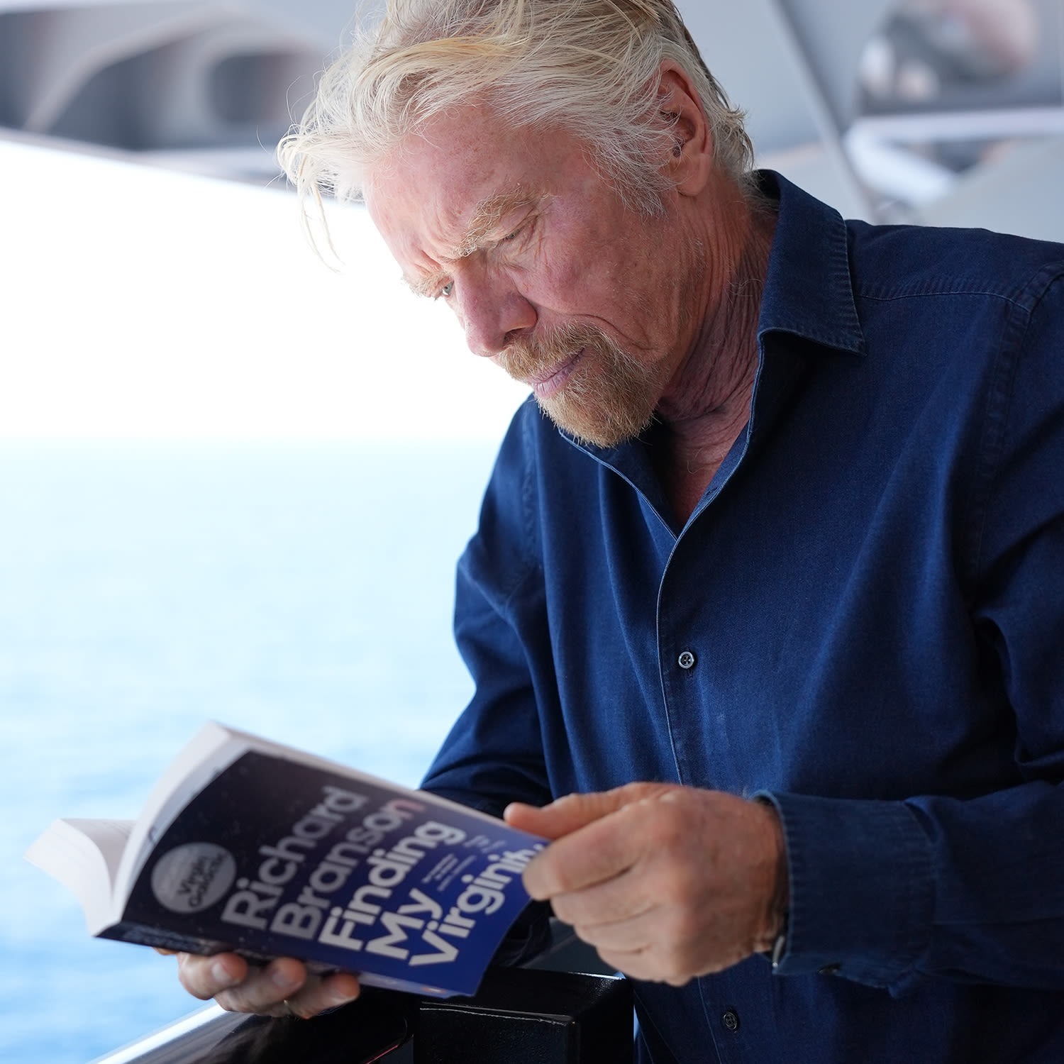 Richard Branson reading a copy of Finding My Virginity