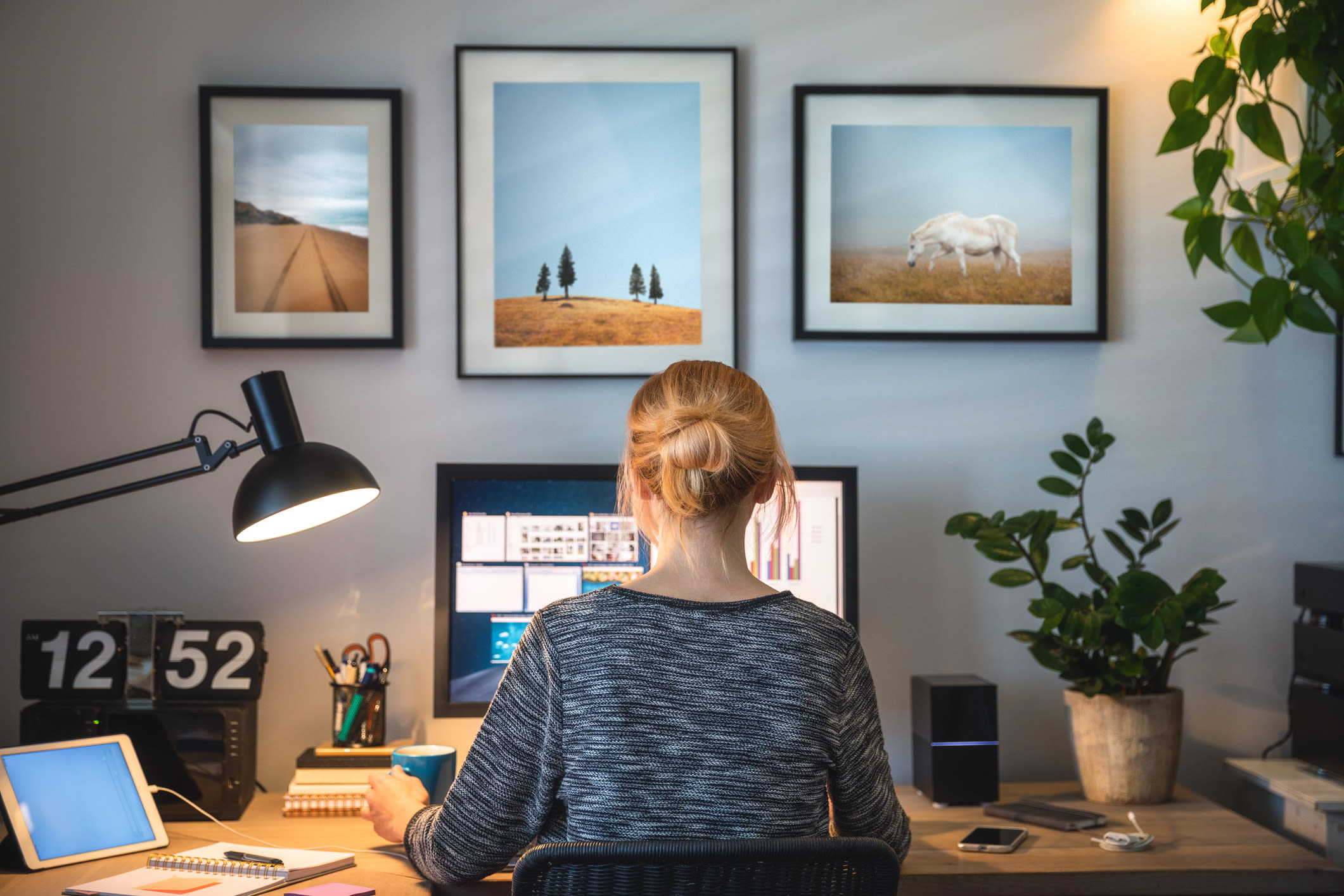 A woman working from home with plants on her desk