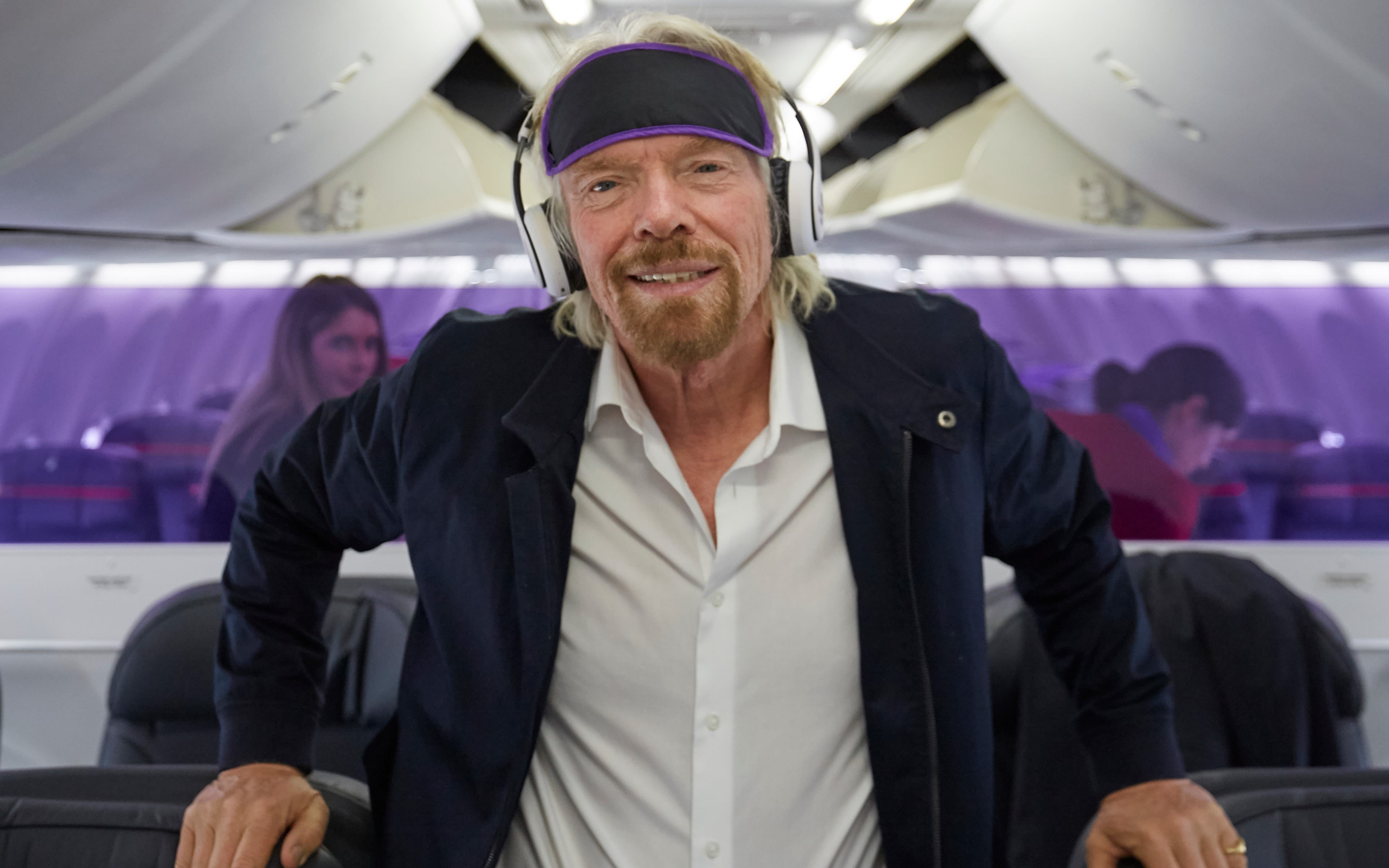 Richard Branson wearing headsets and an eye mask on Virgin Australia's meditation flight in 2018