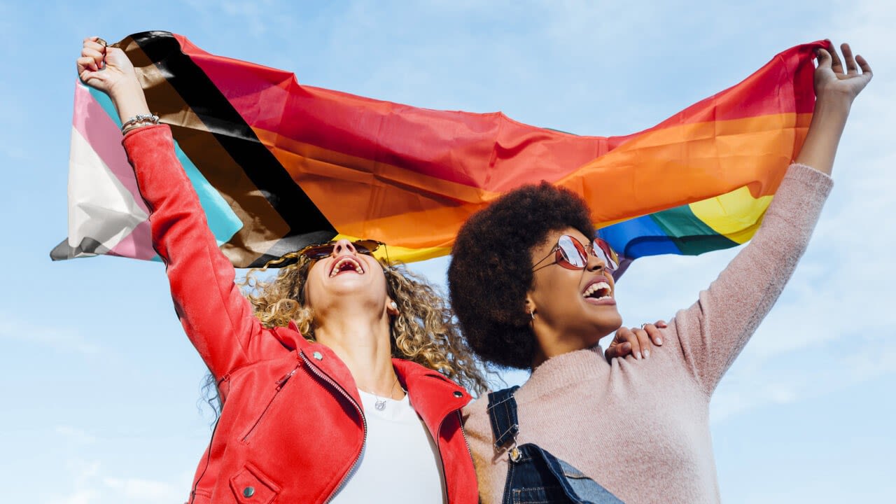 Two women holding the Pride flag