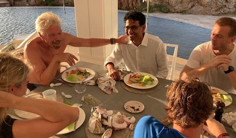 Richard Branson sat around the table eating with other people