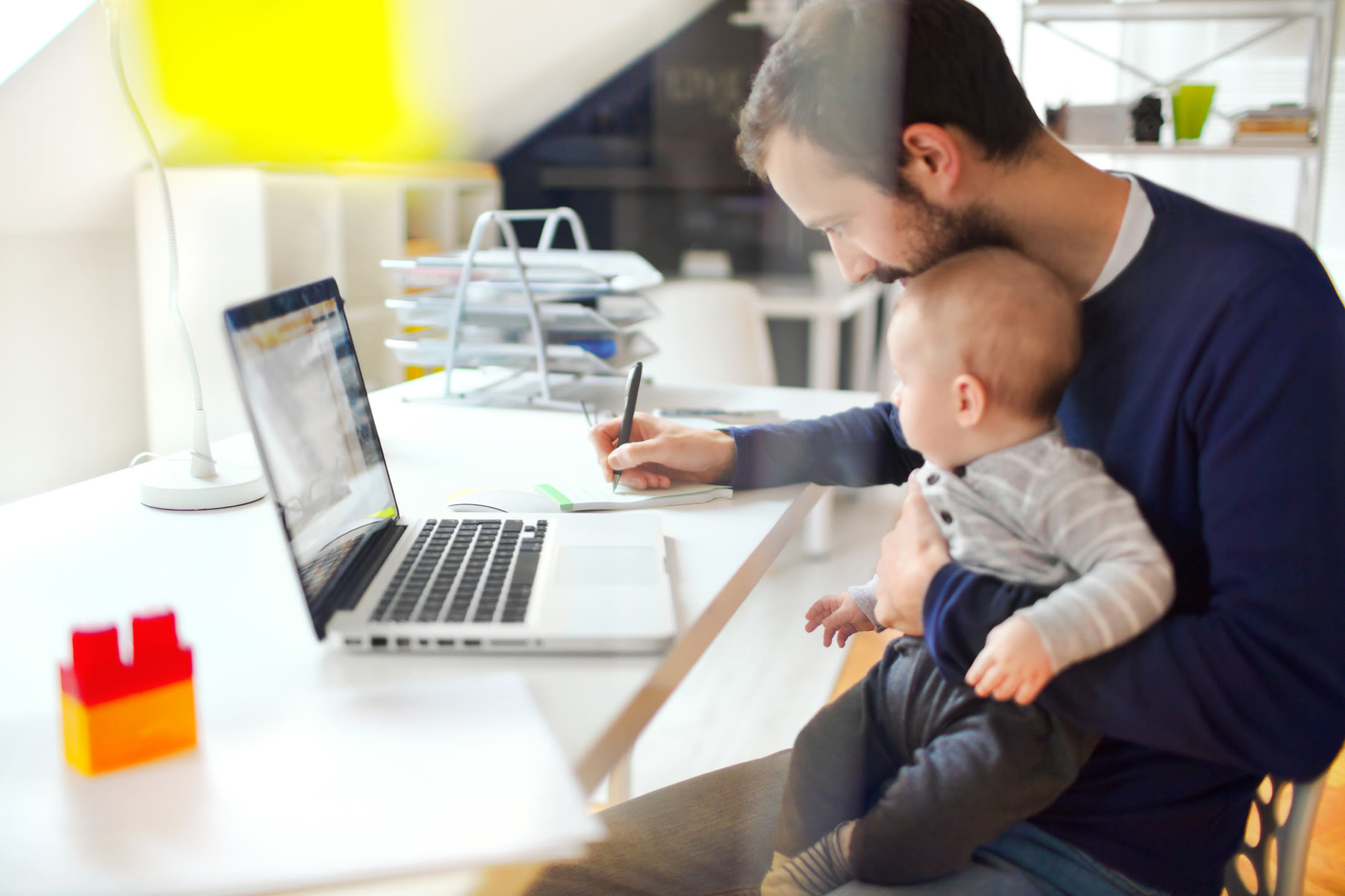 A dad working from home with a baby on his lap