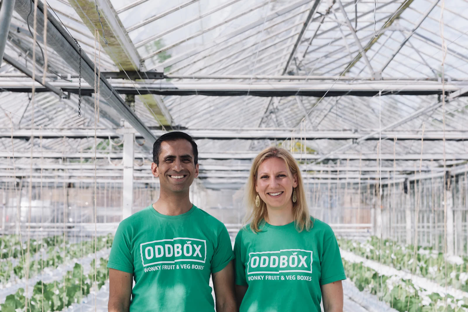 The founders of ODDBOX smile inside a greenhouse