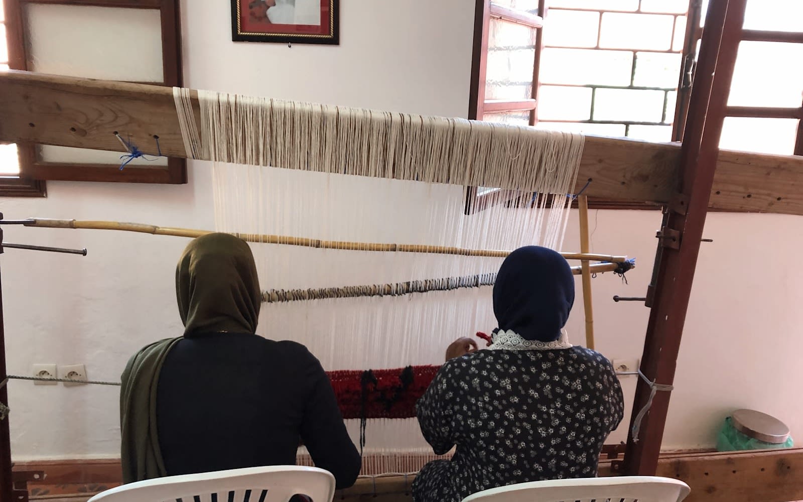 Two ladies weaving a rug at the craft centre