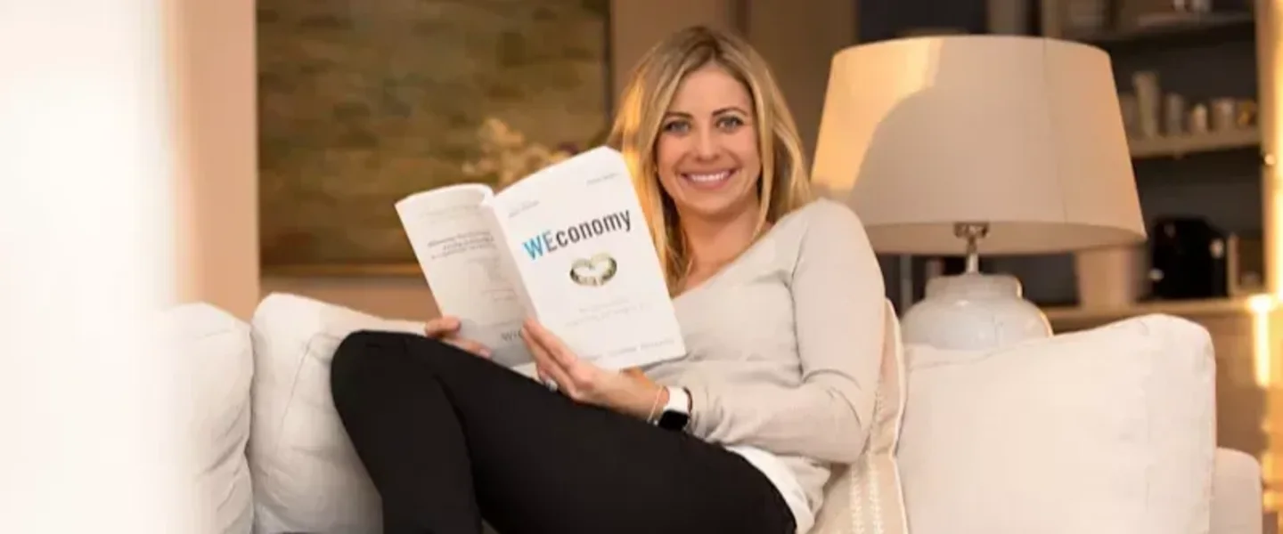 Holly Branson on sofa with a copy of WEconomy 