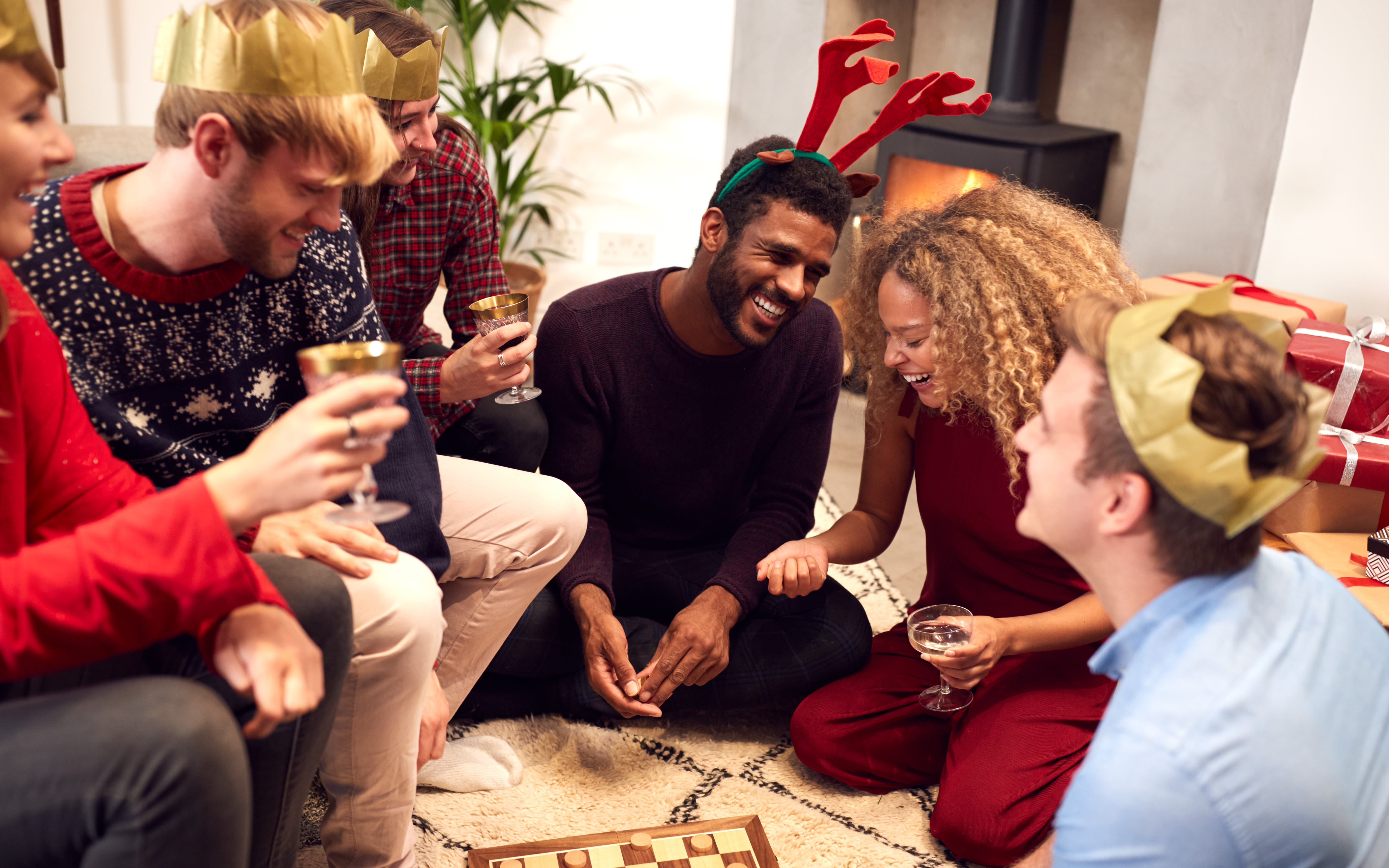 A group of friends play board games after Christmas dinner