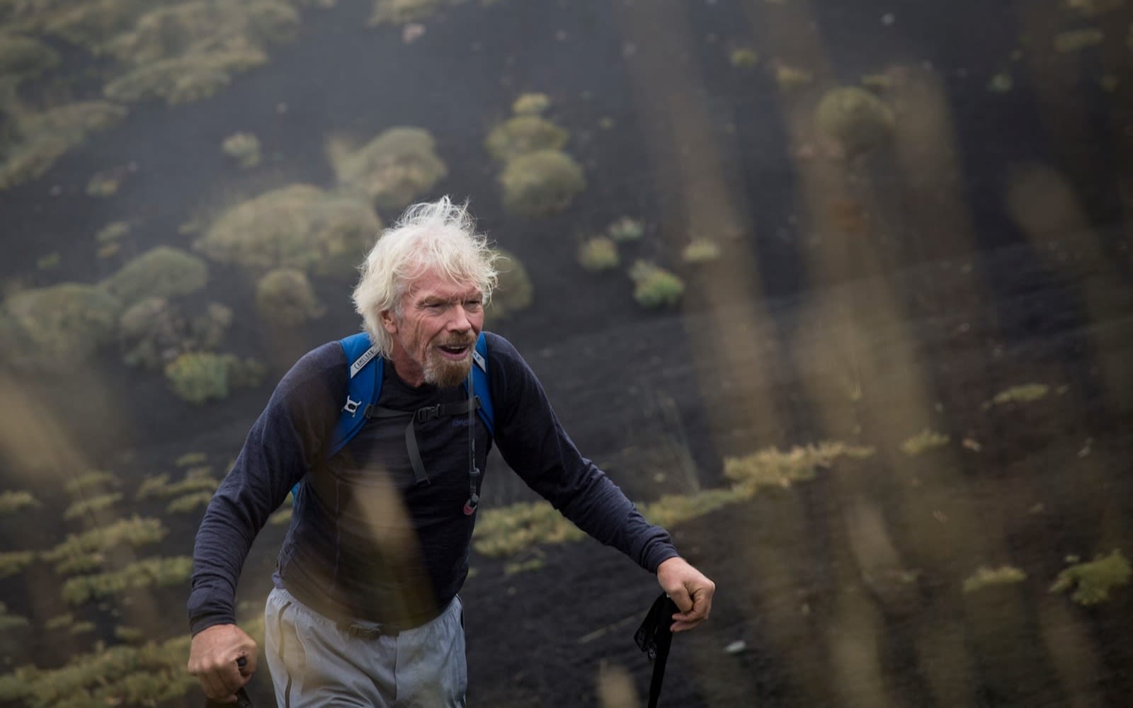 Richard Branson hikinh up a hill