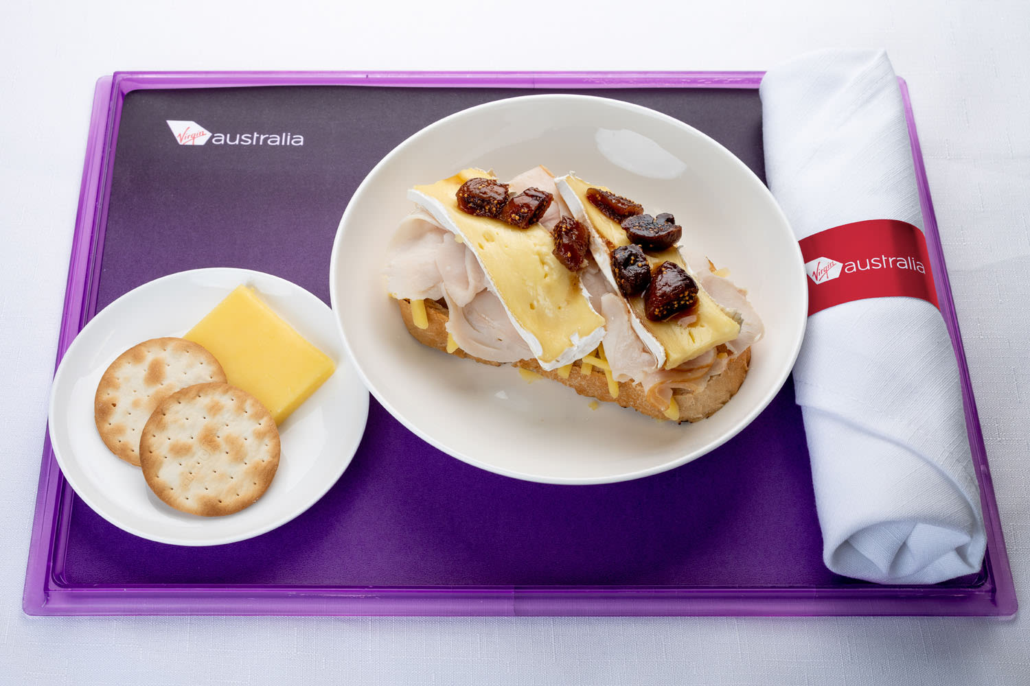 Turkey, brie and fig jam sourdough melt served with cheese and crackers Business Class offering Virgin Australia