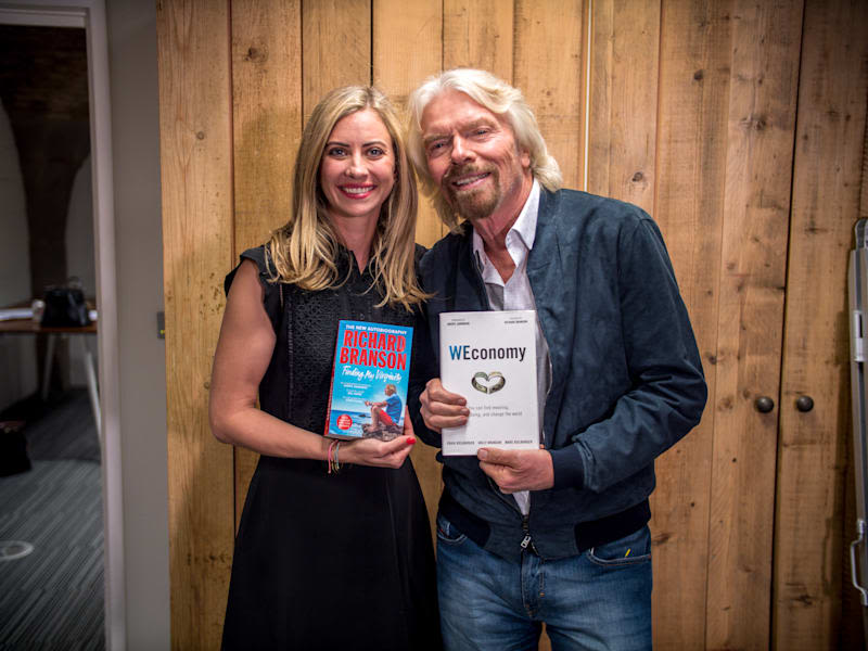 Richard Branson and Holly Branson holding up each other's books during an author interview in 2018