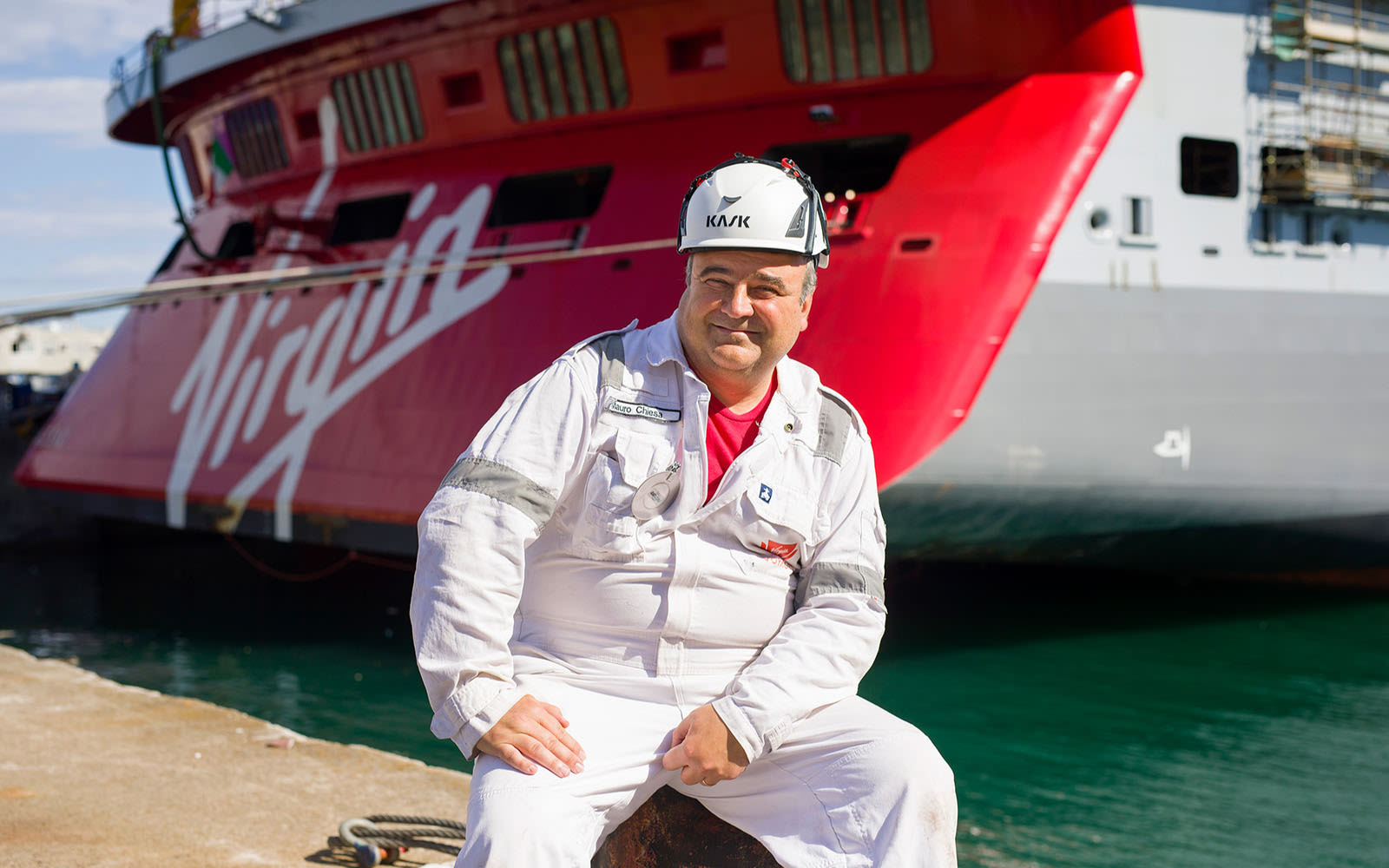 Virgin Voyages crew member - Mauro Chiesa - in front of the Scarlet Lady