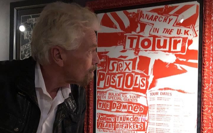 Richard Branson looks at an old Sex Pistols poster inside Virgin Hotels Las Vegas
