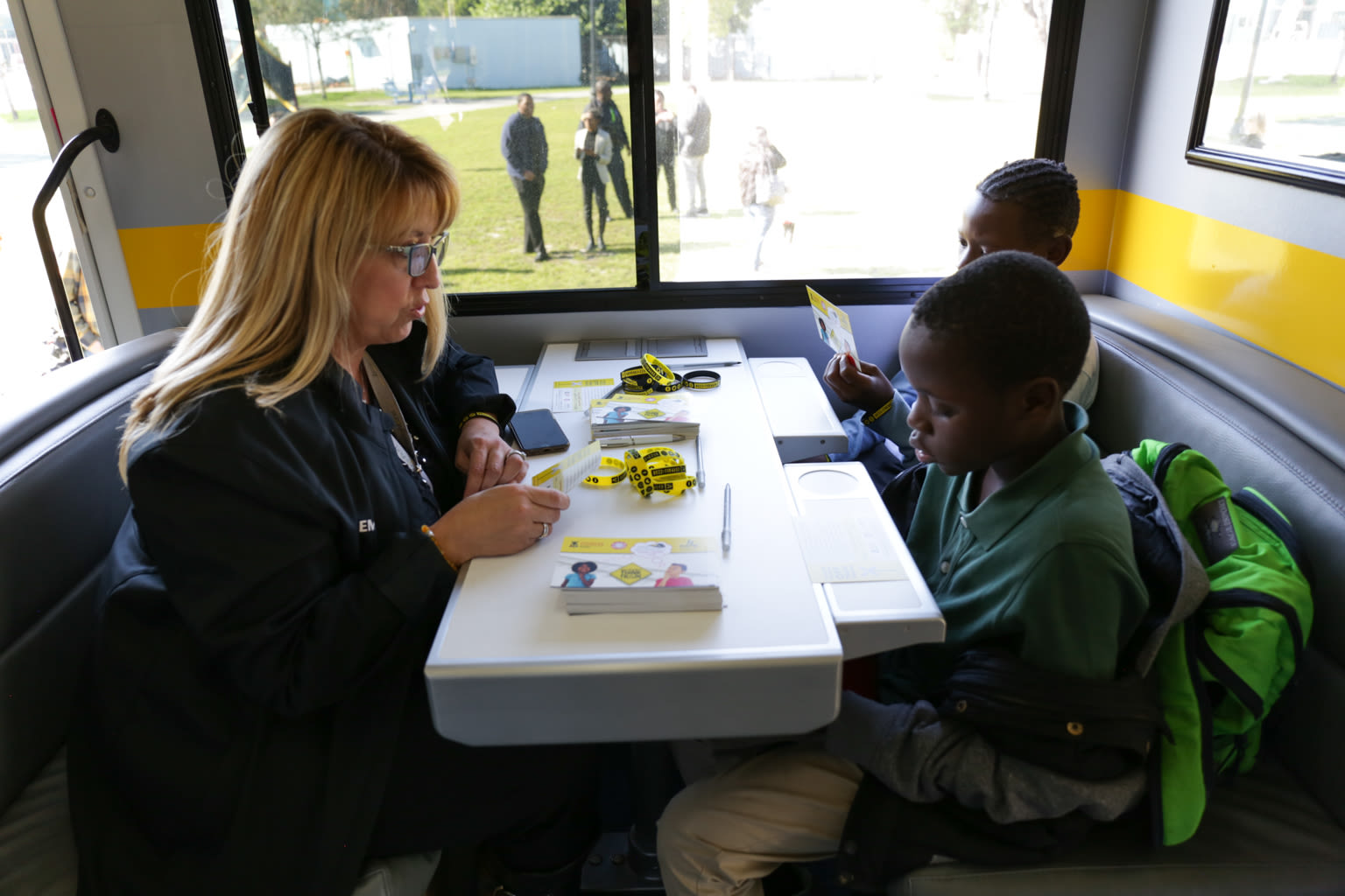 A woman sitting opposite two children at a table