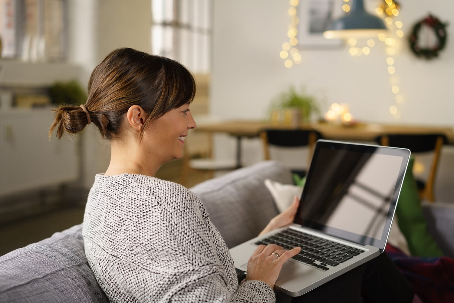 A woman using her laptop while sitting on the sofa