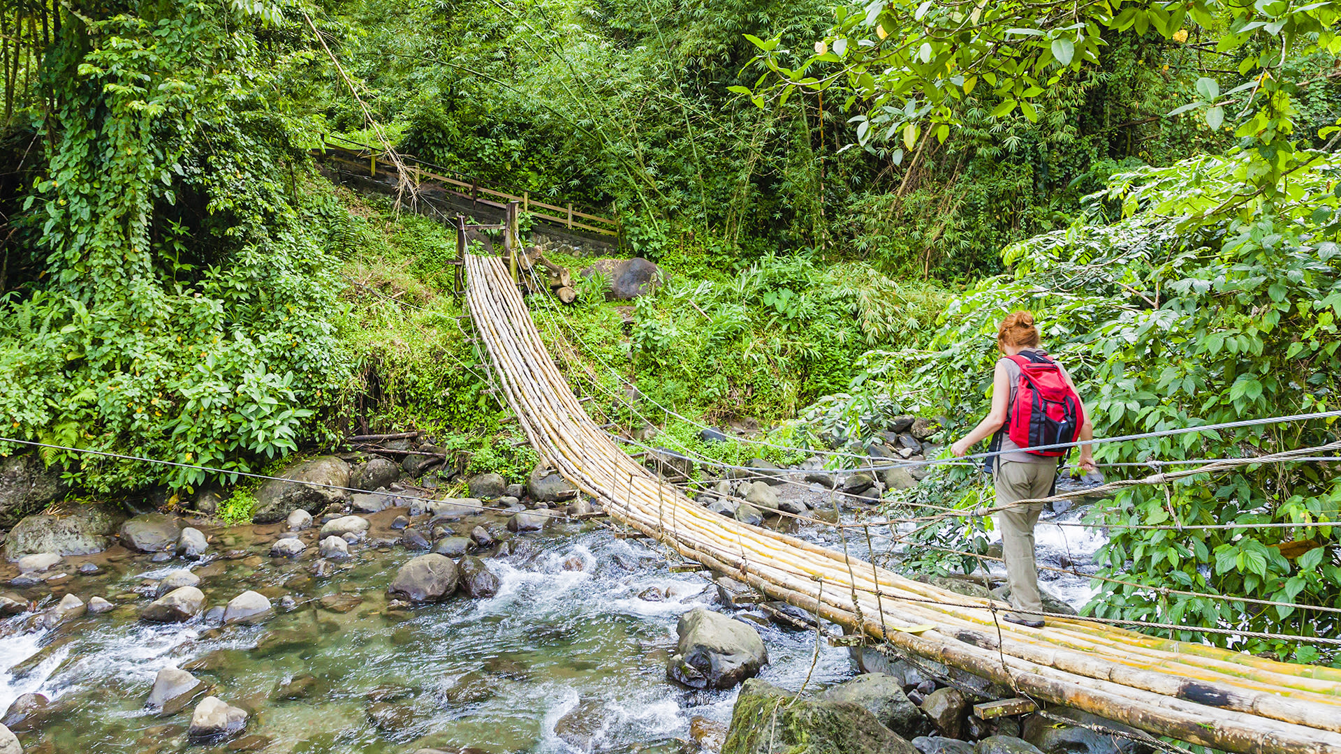 A woman walking across a rope bridge