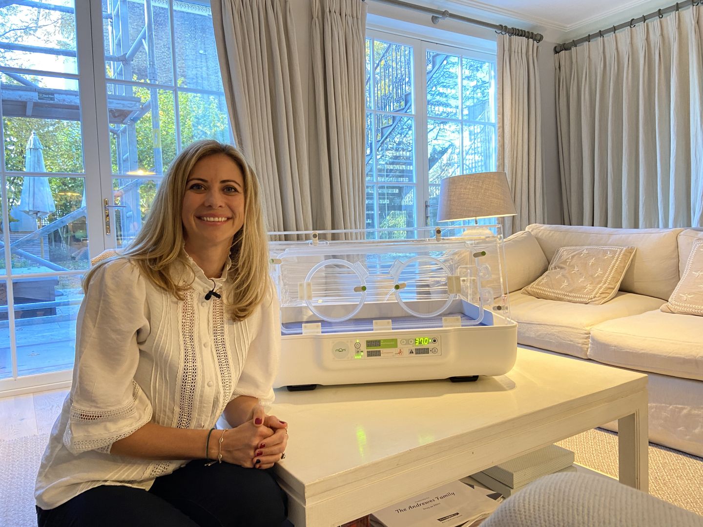 Holly Branson smiles next to a mOm Incubator