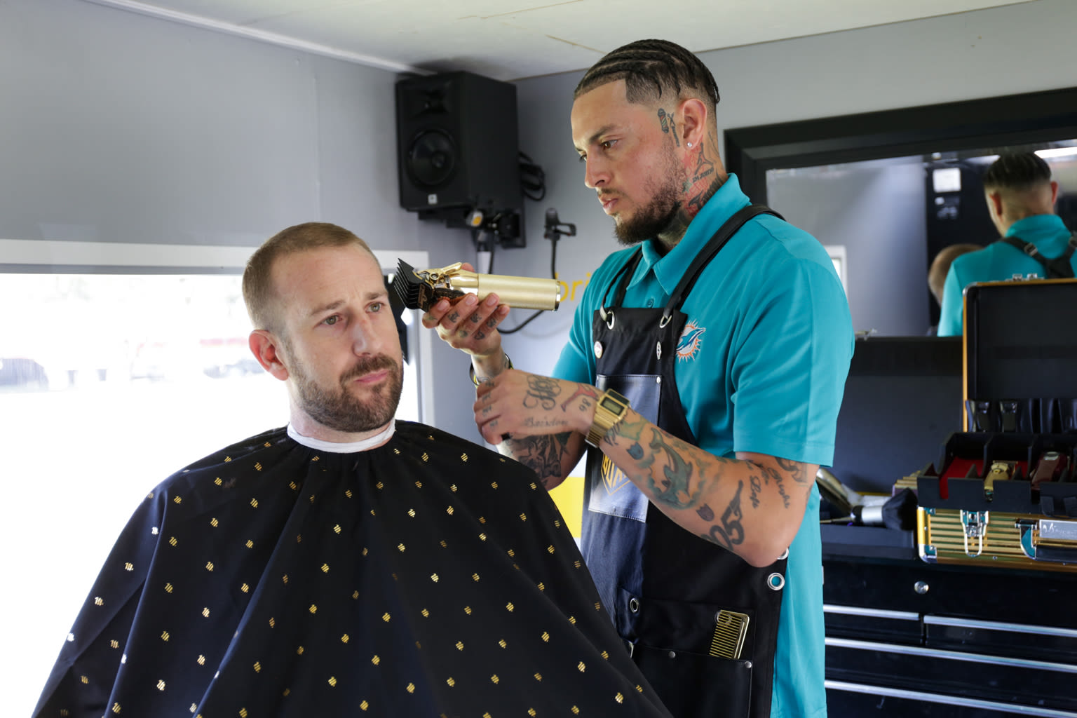 A barber cuts hair at the Virgin Trains USA Buzz Box event to improve rail safety awareness