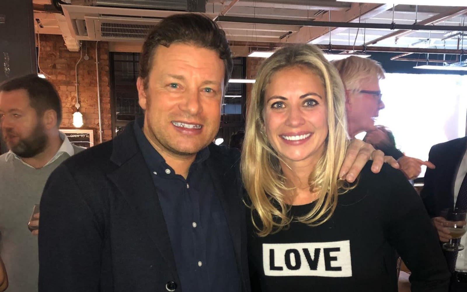 Holly Branson and Jamie Oliver in a room full of people.