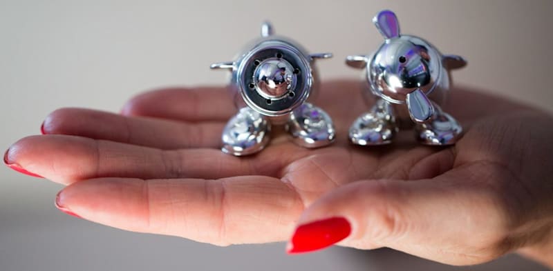 A woman holds Virgin Atlantic salt and pepper shakers shaped like aeroplanes, known as Wilbur and Orville
