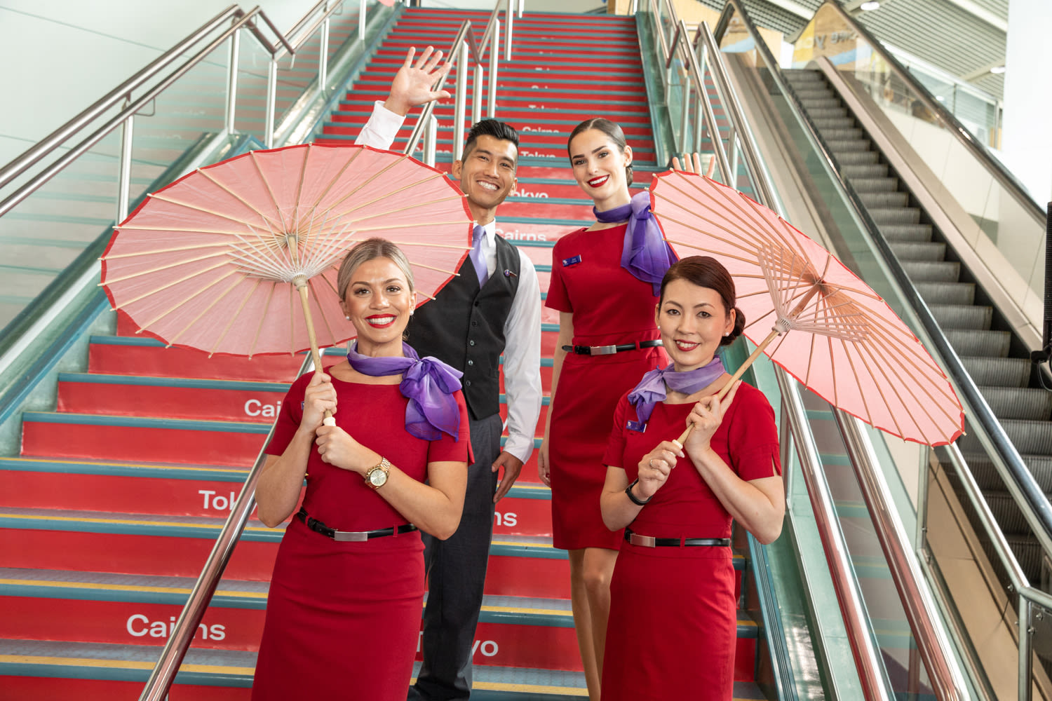 Four Virgin Australia cabin crew celebrating the announcement of flights from Cairns to Tokyo