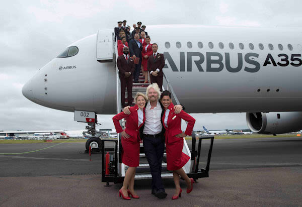 Richard Branson with Virgin Atlantic cabin crew in front of an Airbus A350