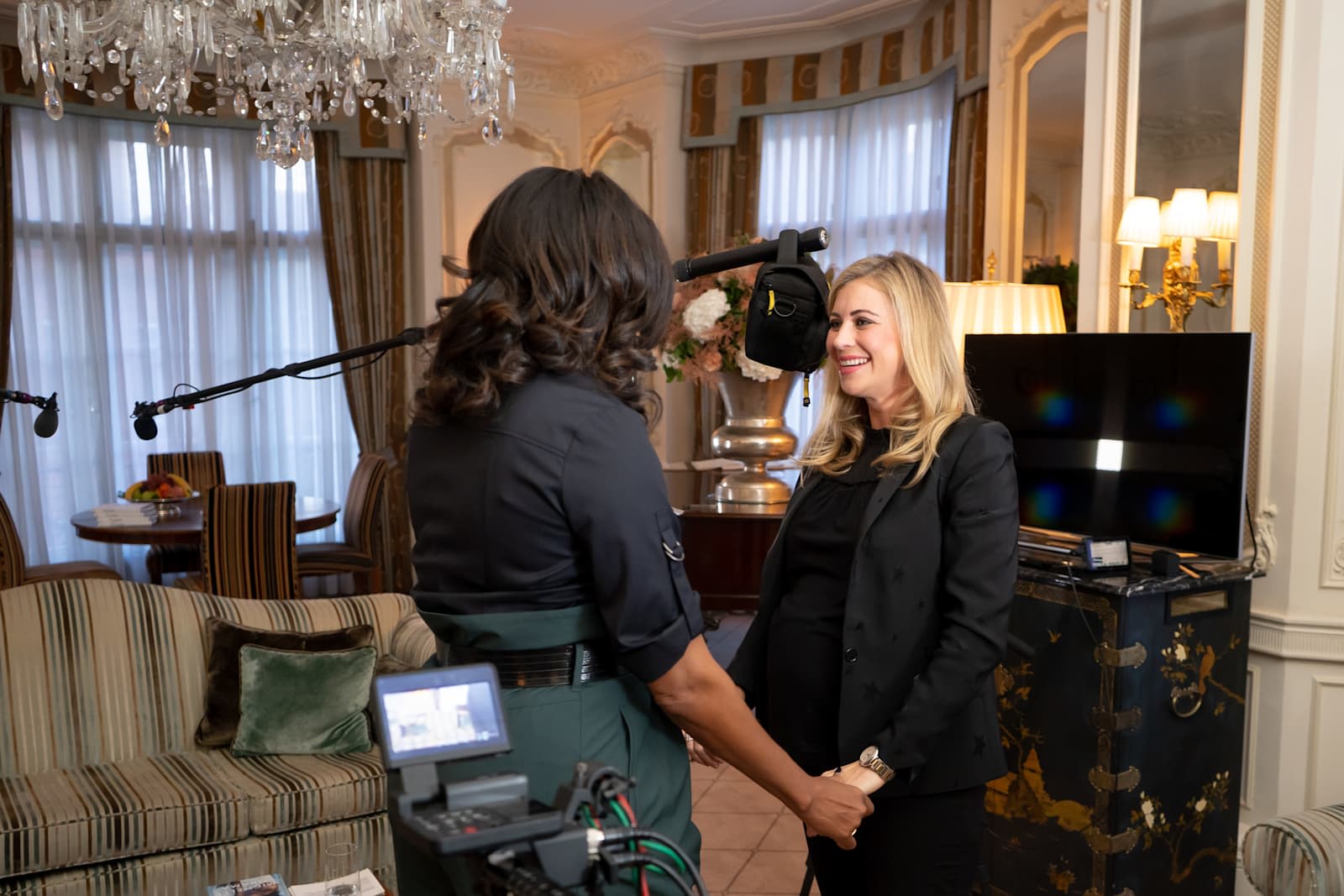 Holly Branson smiling at Michelle Obama with camera equipment in the background