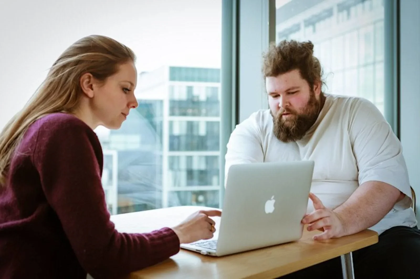 two auticon consultants looking over a laptop