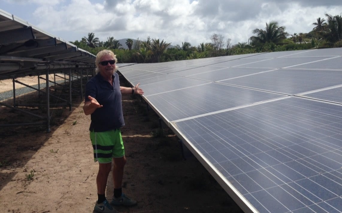 Richard Branson stands next to the solar panels on Necker Island