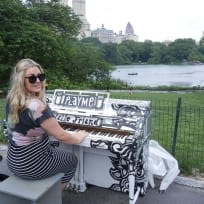 Alice Nash playing a black and white piano that says play me