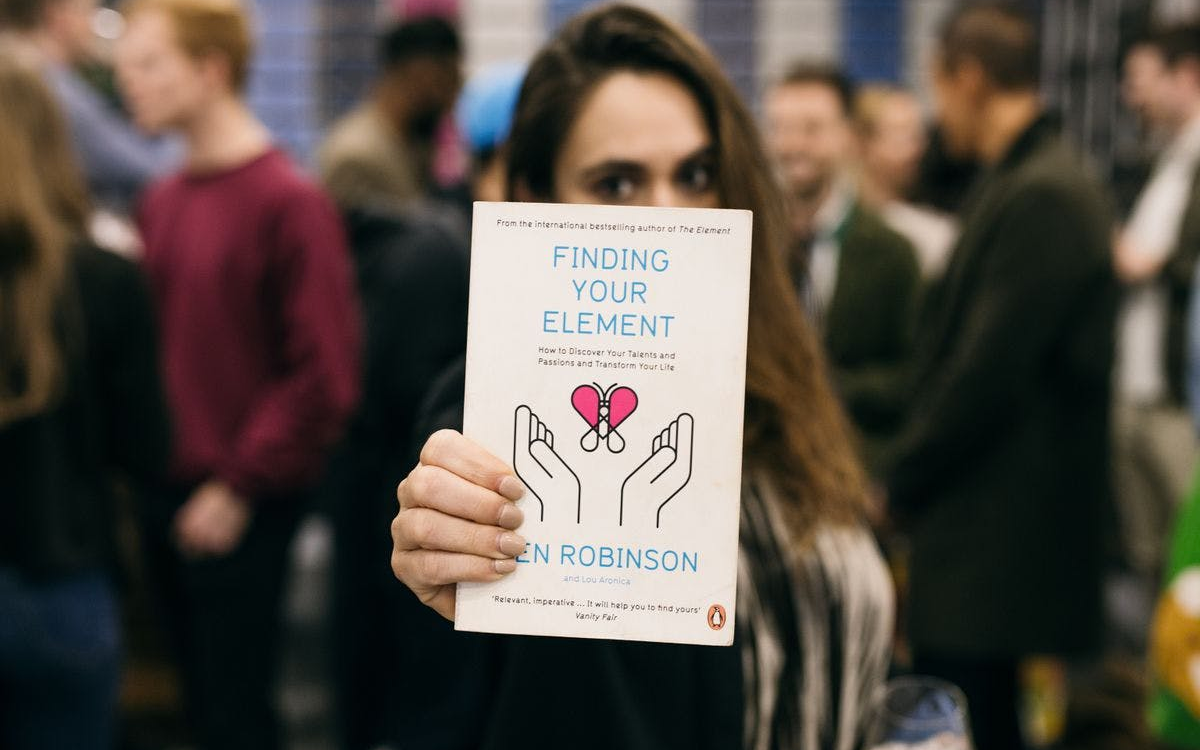 Image of brunette lady holding a book called 'Finding Your Element'.