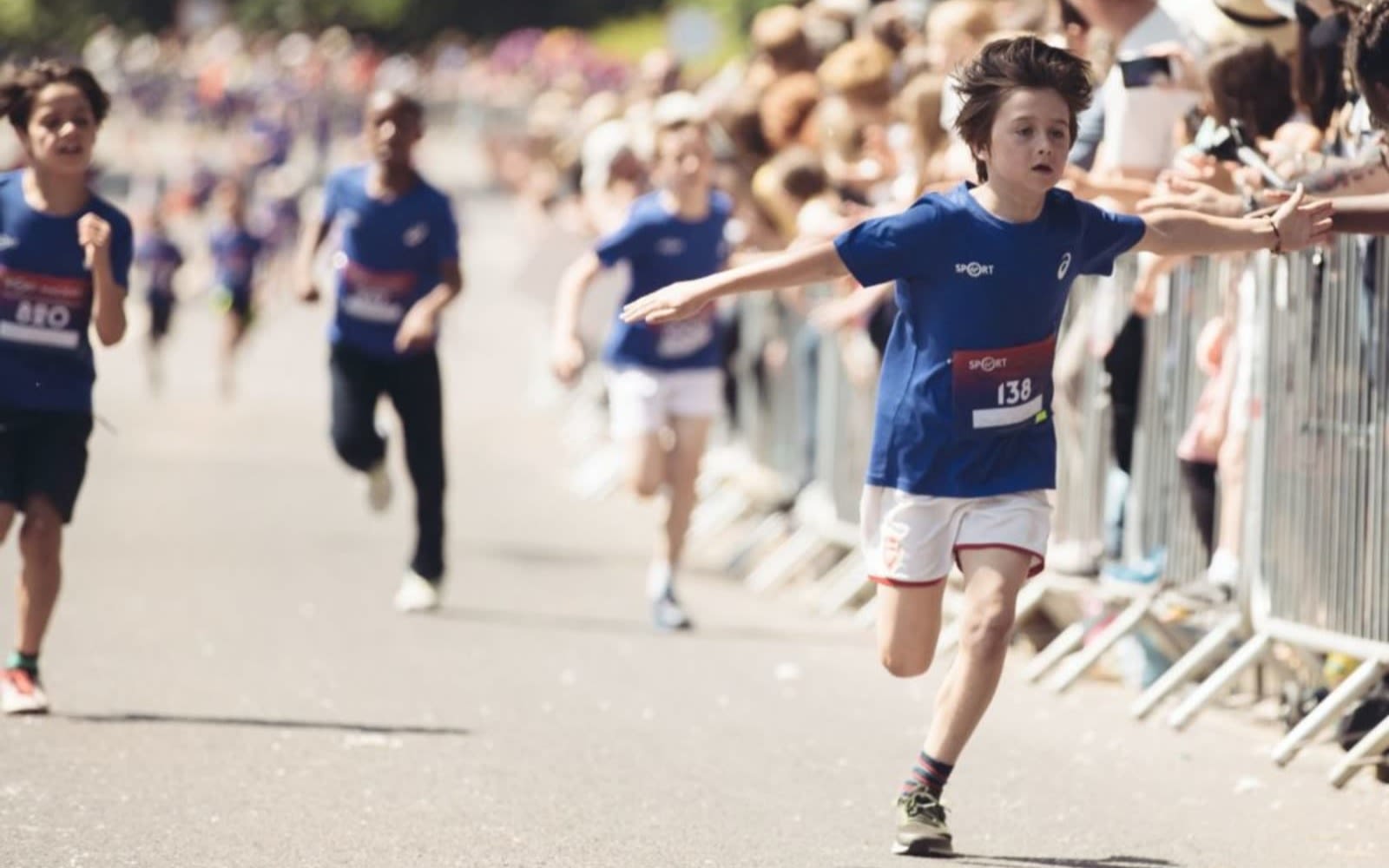 A child runs across the finishing line of the Wheetabix Protein Youth Challenge