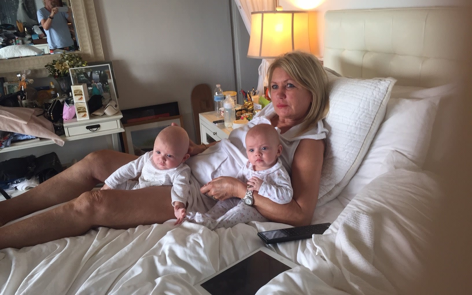 Joan Branson lying on a bed with her grandchildren, Etta and Artie