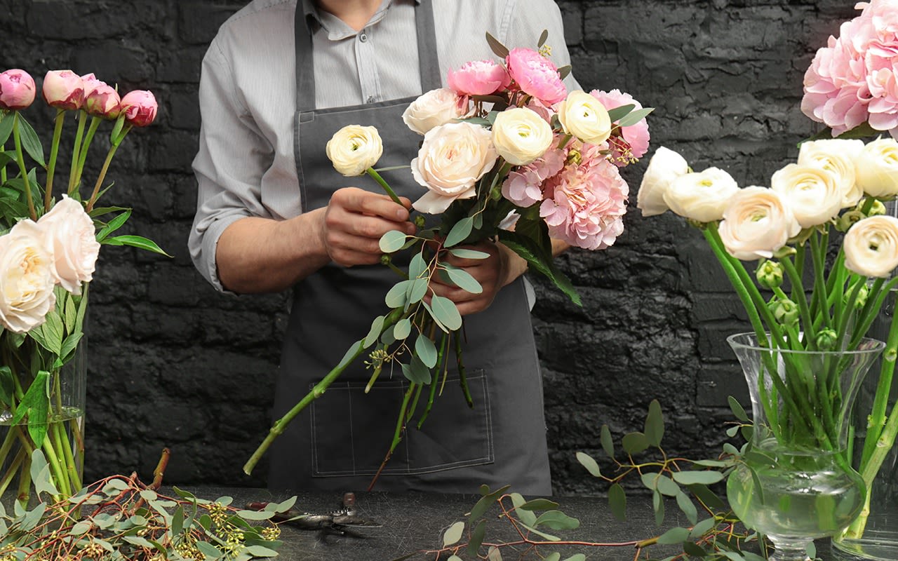 Image of florist arranging flowers into bouquets.