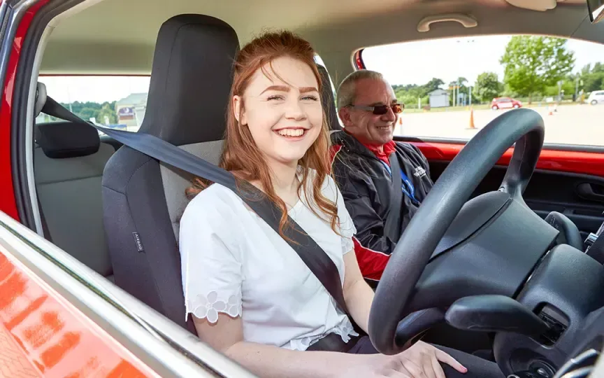An image of a young woman in a car with an instructor