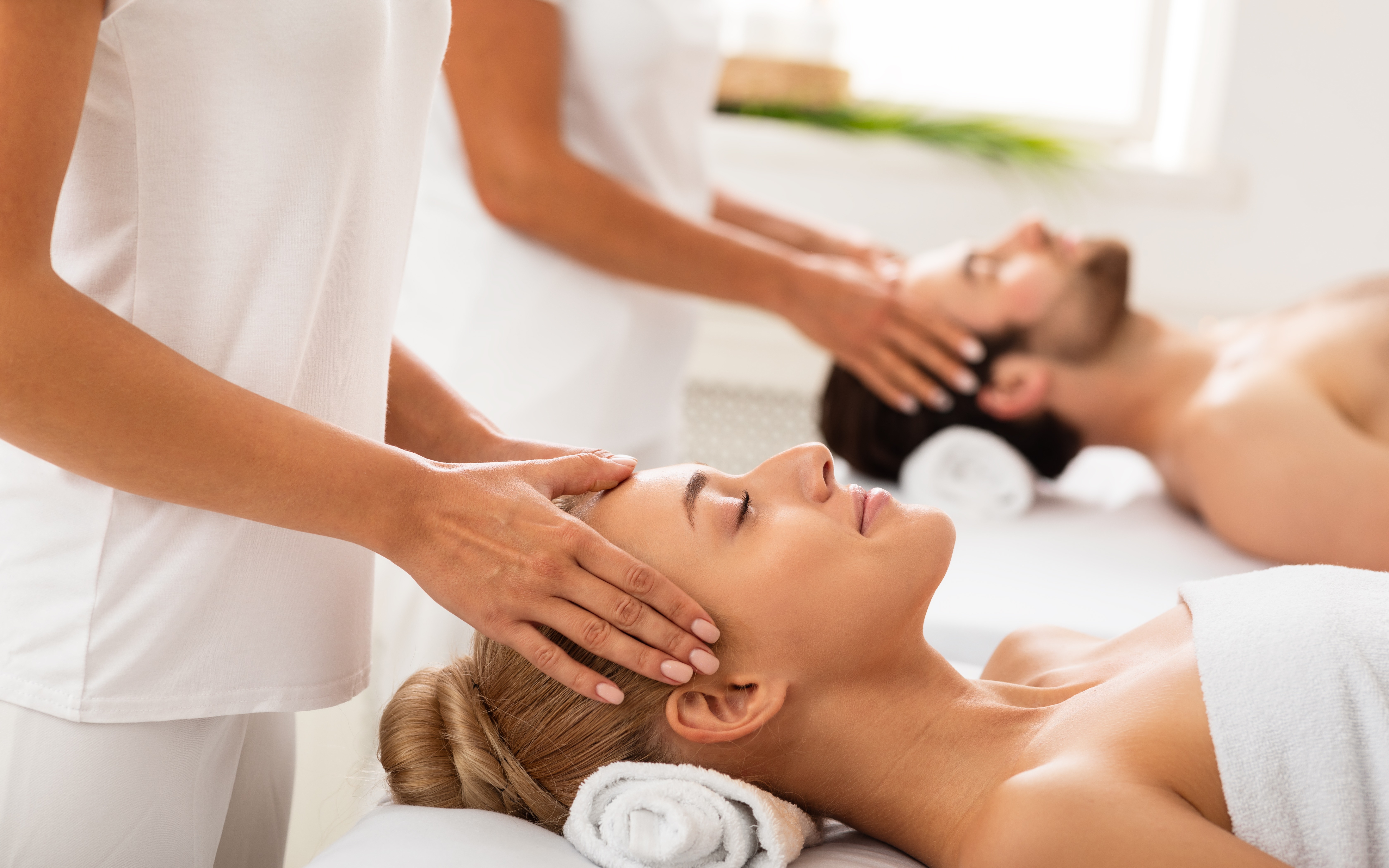 Two people enjoying a head massage during a spa day.